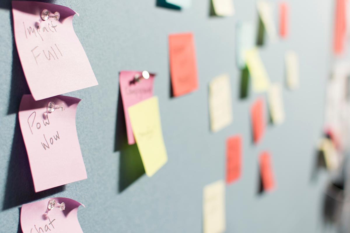 Post-it notes pinned to tack board
